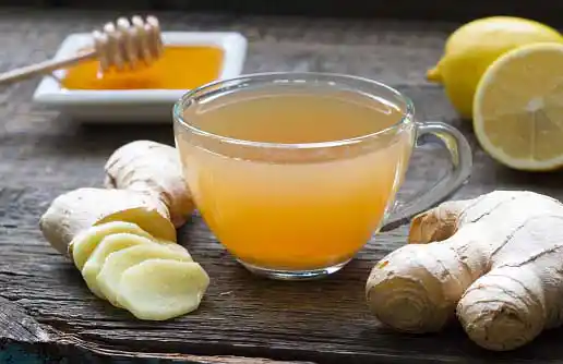 cup of ginger tea with lemon, honey and sliced ginger